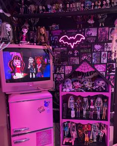 a pink refrigerator freezer sitting next to a shelf with dolls on top of it