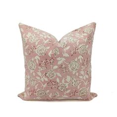 a pink pillow with white flowers on the front and back, against a white background