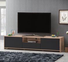 a flat screen tv sitting on top of a wooden entertainment center in a living room