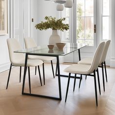 a dining room table with chairs and a vase