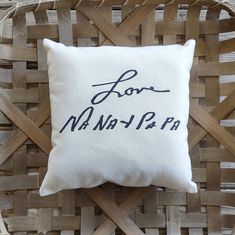 a white pillow with the words love nann - lar on it sitting in a wicker basket