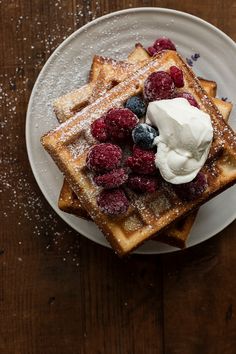 waffles topped with berries and whipped cream on a plate