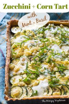 zucchini and corn tart with mint basil in a baking dish on a blue towel