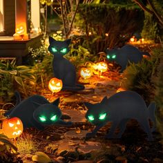 halloween decorations in the shape of cats with glowing eyes