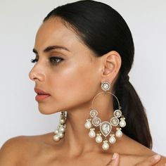 From the heart of NYC comes the chic and elegant Jiyana Pearly Drop Earrings, featuring a gold-plated finish and stunning pearl embellishments. These Blossom Box earrings exude charm and sophistication, elevating any outfit and adding a touch of versatility to your jewelry collection. Handcrafted Metal: Metal Alloy, Gold Plated Stone: Pearls, Kundan Stones (Faux) Length: 3.5" Width: 2.5" Delivery: 7-14 Days (due to high demand of this style!) Glamorous Pearl White Jewelry With Pearl Drop, Glamorous Teardrop Pearl Jewelry, Glamorous Pearl Earrings Set, Pearl Embellished Earrings For Festive Occasions, Elegant Chandbali Chandelier Earrings With Pearl Drop, Glamorous Pearl White Pearl Drop Earrings, Elegant Metal Chandbali Bridal Earrings, Elegant Chandbali Bridal Earrings In Metal, Festive Pearl Drop Earrings In Metal