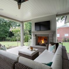 an outdoor living room with couches and a fireplace