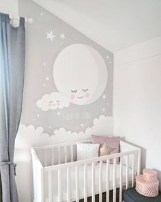 a baby's room with a crib and wall mural