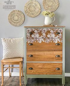 an old dresser has been transformed into a decorative piece with flowers on it and two wicker wall hangings above