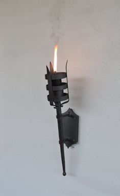 a wall mounted candle holder on the side of a white wall