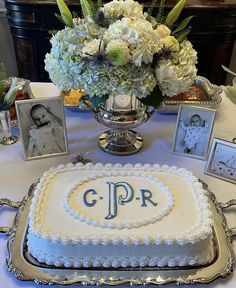 there is a cake on the table with pictures and flowers in front of it that says g p r