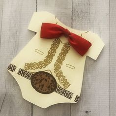 an ornament made to look like a shirt with a red bow on it