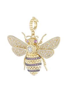 a gold bee charm with diamonds and pink stones on it's back, sitting in front of a white background