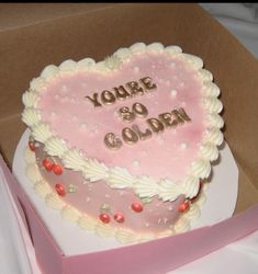 a pink heart shaped cake sitting on top of a box