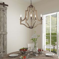 a dining room table with plates, silverware and flowers in the center surrounded by shutters