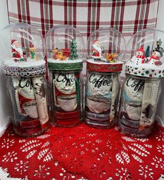 four glass jars filled with coffee beans and christmas decorations