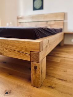 a wooden bed frame sitting on top of a hard wood floor