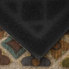 a black tie laying on top of a carpeted floor next to an area rug