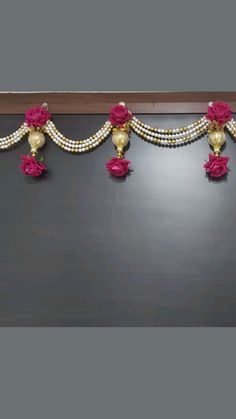 a black table topped with pink flowers and pearls