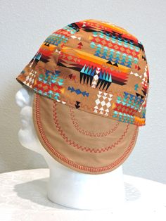 a white mannequin head wearing a brown hat with colorful designs on it's brim