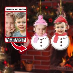 two children wearing christmas hats and scarfs are hanging from a tree ornament