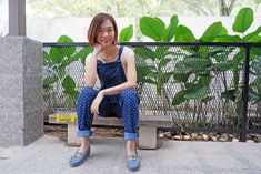 a woman sitting on top of a wooden bench