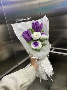 a person holding a bouquet of flowers in their hand