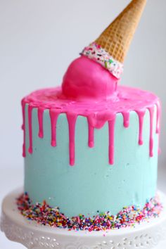 a birthday cake decorated with sprinkles and an ice cream cone on top