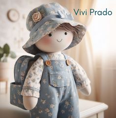 a small doll with a blue hat and overalls is sitting on a white table