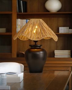 a lamp that is on top of a table in front of a bookshelf