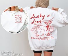 the back of a woman wearing a white sweatshirt with red lettering and an image of a martini