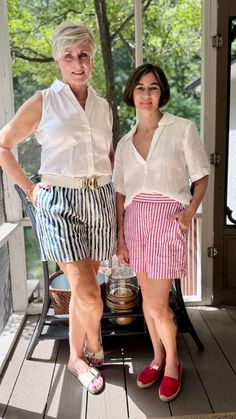 two women standing next to each other on a porch