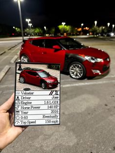 a hand holding up a card with an image of a car in the parking lot