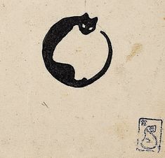 a black cat sitting on top of a piece of paper next to a rubber stamp