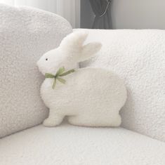 a stuffed rabbit sitting on top of a white couch