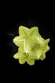 an overhead view of a yellow object on a black background with the light reflecting off it's surface