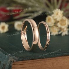 two wedding rings sitting on top of a book