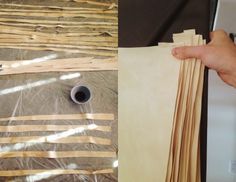 a person is holding some wood strips in their hand and there are other pieces of paper on the table