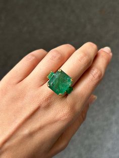 For Sale on 1stDibs - Make a statement with this three stone cocktail ring, with 19.69 carat center stone Zambian Emerald with 2.01 carat side-stone Emeralds. All set in 18K Luxury Emerald Gemstones With Prong Setting, Luxury Emerald Cut Gemstone With 17 Jewels, Luxury Three Stone Gemstones For Anniversary, Luxury Hallmarked Emerald Gemstones, Luxury Multi-stone Emerald Cut Emerald Ring, Luxury Oval Three Stone Emerald Ring, Luxury Oval Emerald Ring With Three Stones, Luxury Yellow Gold Emerald Gemstones, Luxury Emerald Gemstones In Yellow Gold