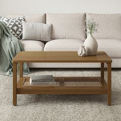 a living room with a couch, coffee table and pillows on the floor in front of it