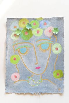 a piece of paper with flowers on it and a woman's face in the middle