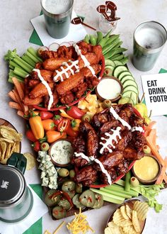 a football platter with meat, veggies and dips on the side