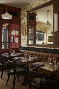 an empty restaurant with tables and chairs in front of a large mirror on the wall