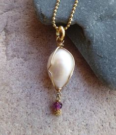 "July is Ruby month! This lovely necklace features an egg shaped baroque fresh water pearl AAA quality. Lustrous and white, the wire wrapped 5/8\"pearl holds a dangling 3mm faceted natural ruby. The pendant itself drops at a total length of 1 1/4\" and suspends from a delicate gold filled diamond-cut ball chain, 20\" in length. Makes a stunning cleavage jewel. Fresh Water baroque pearls are cultured from the Margaritifera mollusk. Baroque pearls are more indicative of fresh water rather than sal 15th Wedding Anniversary, 30th Wedding Anniversary, Ocean Jewelry, Fresh Water Pearl, June Birthstone, Water Pearls, July Birthstone, Lovely Necklace, Egg Shape