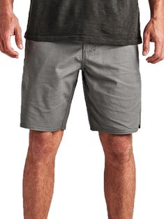 a man in grey shorts standing with his hands on his hips