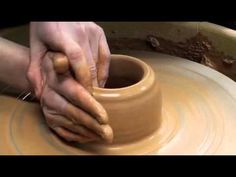 a person is making a vase on a potter's wheel with their hands in it