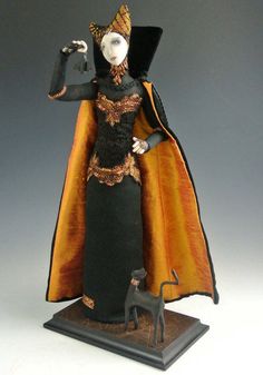 a figurine is dressed in black and orange with a cat on the side