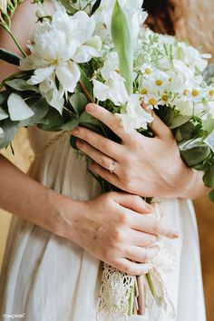 a woman holding a bouquet of flowers in her hands