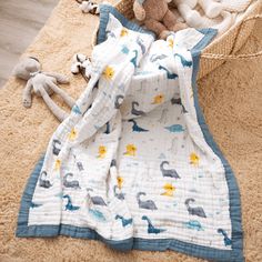 a baby's blanket and stuffed animal are laying on the floor next to a teddy bear