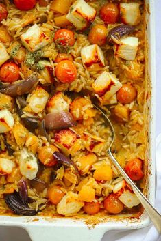 a casserole dish filled with rice, vegetables and tofu in tomato sauce