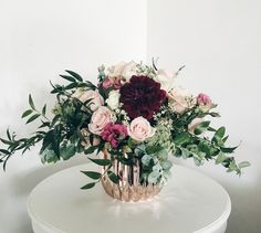 a vase filled with flowers sitting on top of a white table